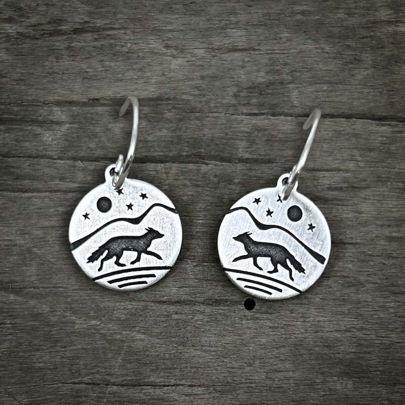 Fox Run Earrings crafted with a fox design against mountains and stars in matte sterling silver finish.