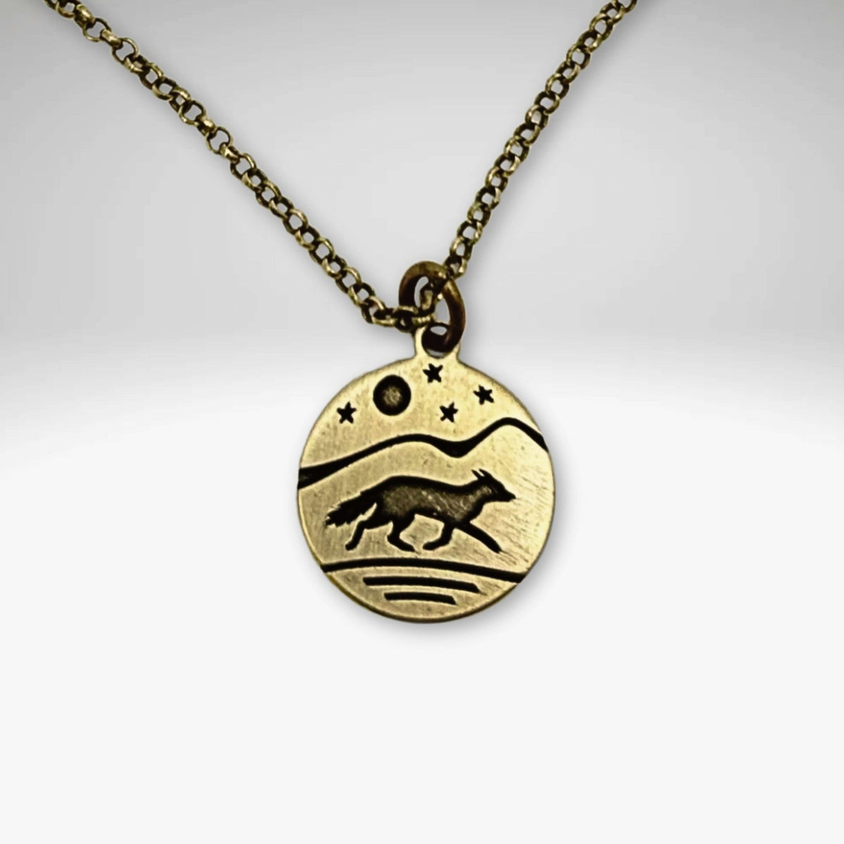 Fox Run Necklace featuring a handmade pendant of a fox running under a night sky, available in Antique Brass finish.