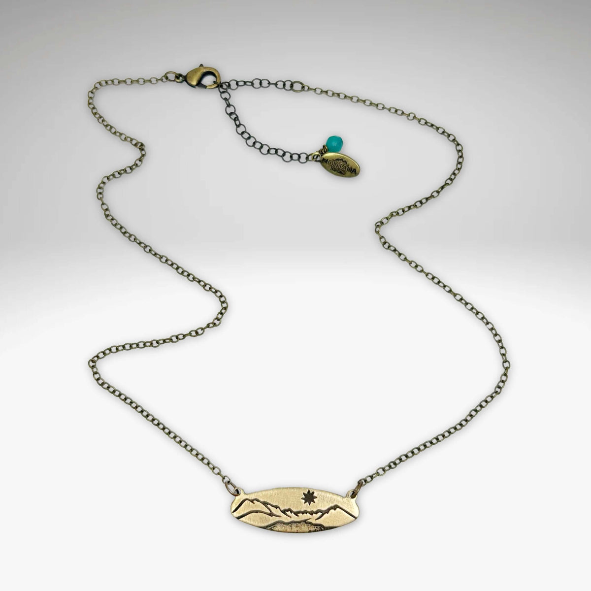 Glacier View Necklace featuring an antique brass finish and adjustable chain from 16" to 18".