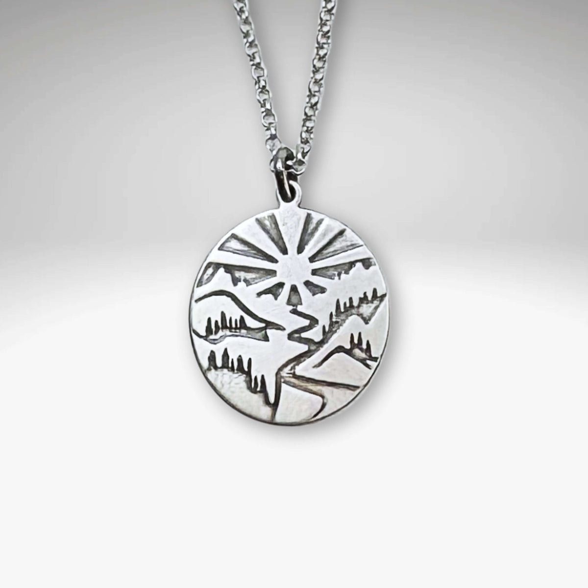Going to the Sun Necklace featuring a detailed mountain pendant on an adjustable chain.