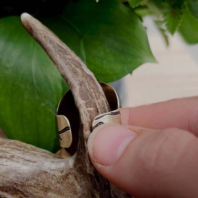 Going to the Sun Road Adjustable Ring showcased on a hand holding an antler, set against greenery.