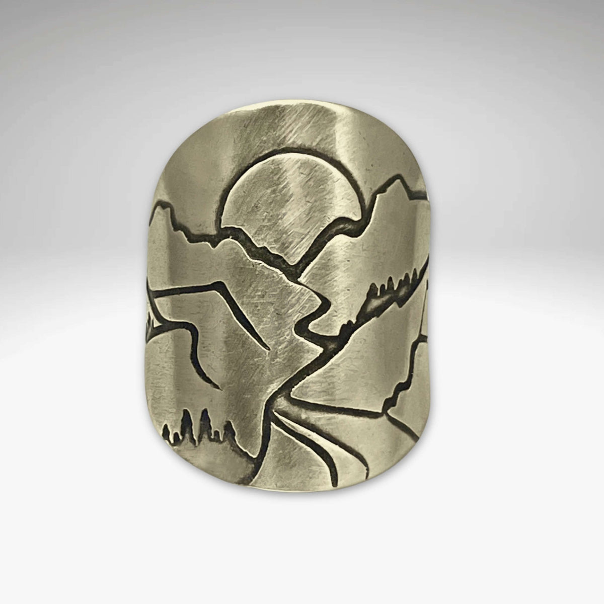 Going to the Sun Road Adjustable Ring featuring etched mountains and sun design in raw brass finish.