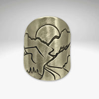 Going to the Sun Road Adjustable Ring featuring etched mountains and sun design in raw brass finish.