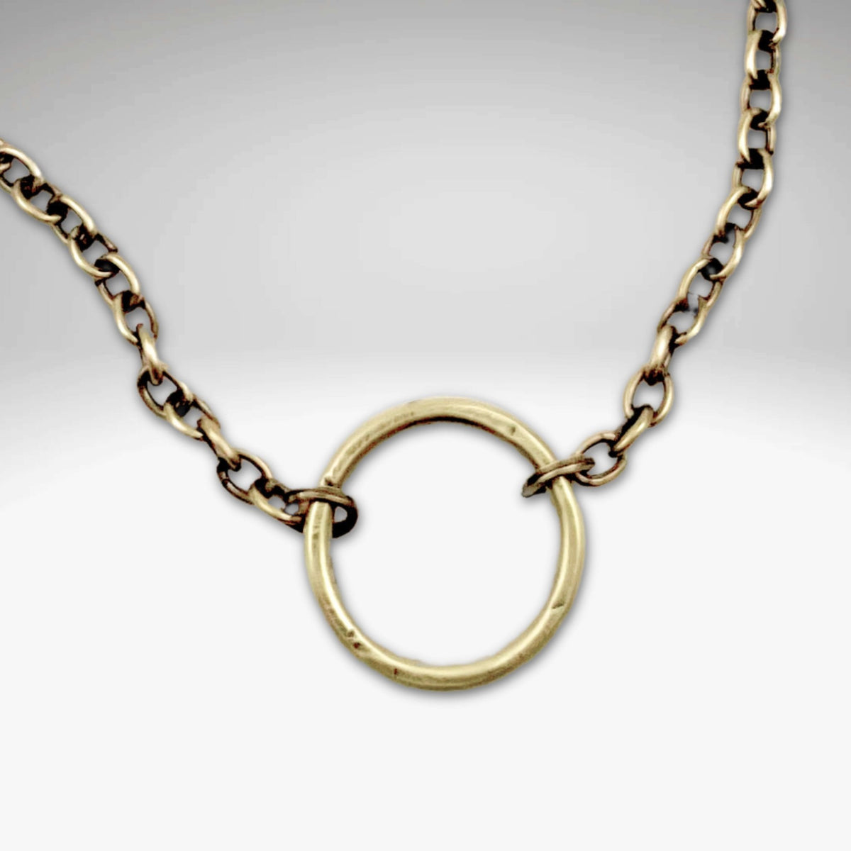Halo Necklace featuring a hammered halo pendant on an adjustable cable chain in antique brass finish.