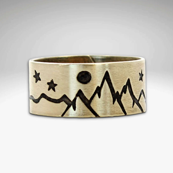 High Alpine Adjustable Ring featuring mountain and star designs in antique brass finish.