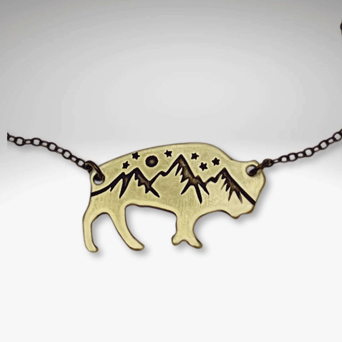 High Alpine Bison Necklace featuring a bison silhouette with mountains and stars design on a chain.
