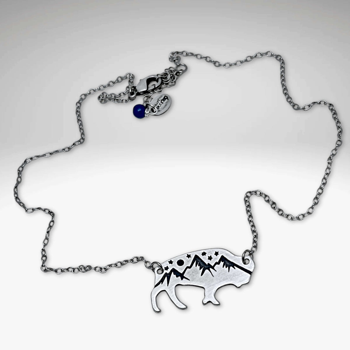 High Alpine Bison Necklace featuring a cutout bison with mountain design on an adjustable silver chain.