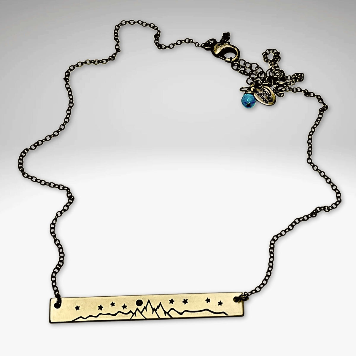 High Alpine Necklace featuring a brass etched mountain design on an adjustable chain.