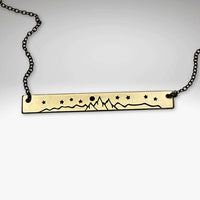 High Alpine Necklace displayed on a chain, featuring a brass pendant with mountain and star etching.