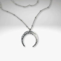 Horned Moon Necklace on satellite chain, featuring a silver pendant and delicate chain, beautifully layered for elegance.