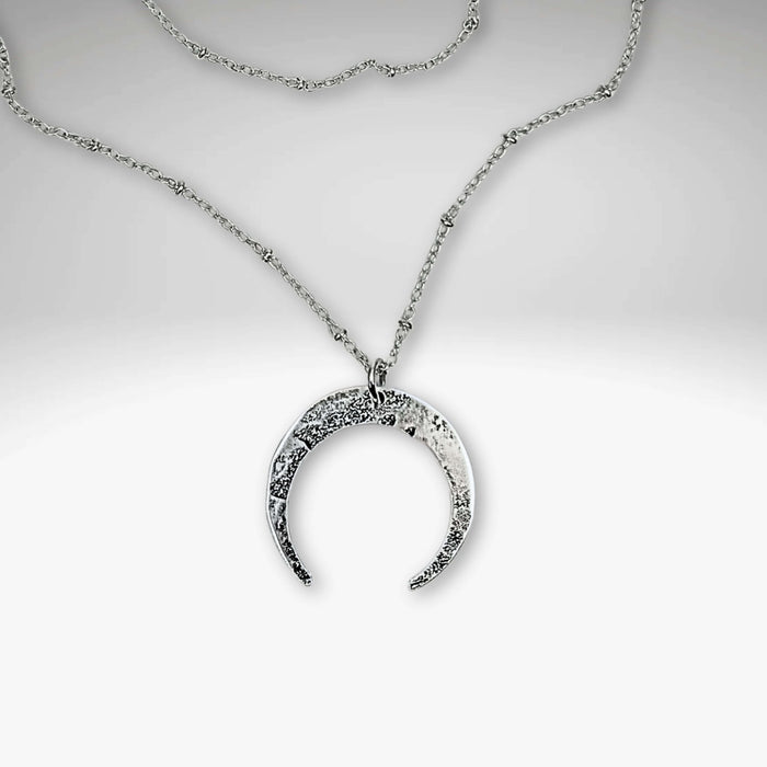 Horned Moon Necklace on satellite chain, featuring a silver pendant and delicate chain, beautifully layered for elegance.