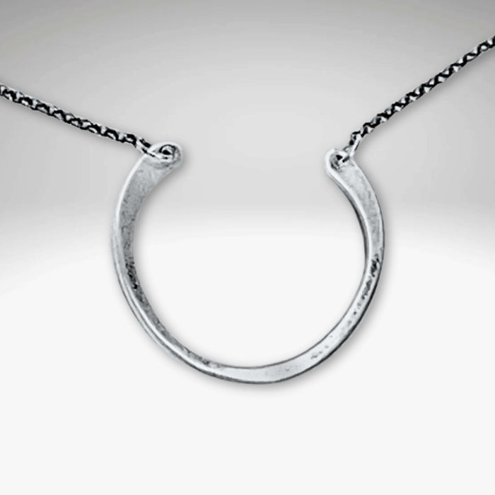Horseshoe Necklace featuring a semi-circle pendant with a hammered finish on a delicate rolo chain.