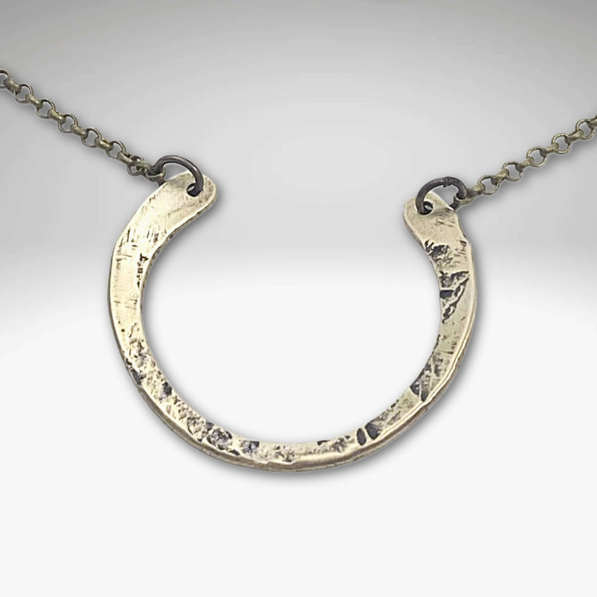 Horseshoe Necklace with a lightly hammered finish on a delicate rolo chain, perfect for everyday wear.