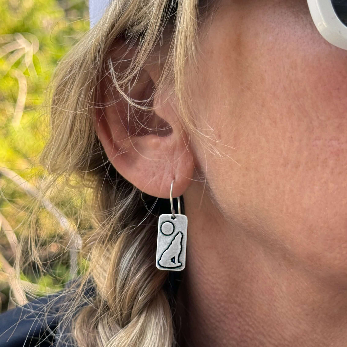 Howl Earrings showcasing a howling wolf design against a full moon, suspended from classic earwire.