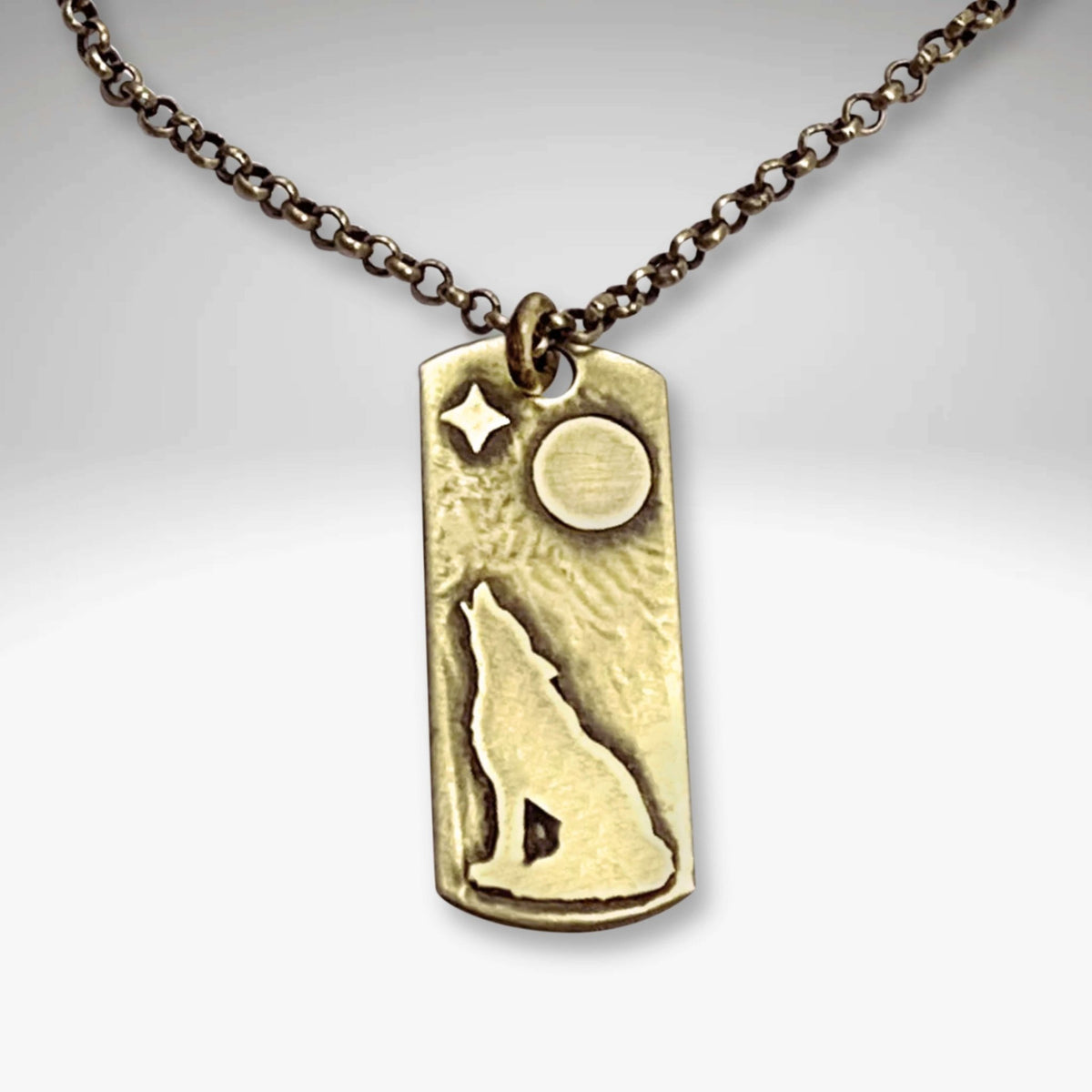 Howl Necklace featuring a wolf design with moon and star on an antique brass pendant.