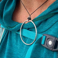 Model wearing a Hula Necklace featuring a circular hoop pendant with a black cord.