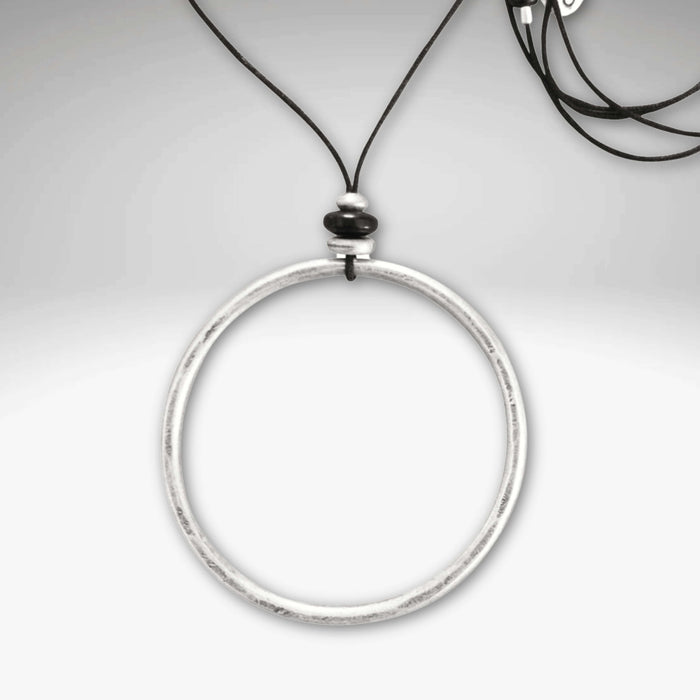 Hula Necklace featuring a 2" diameter raw brass circle hoop with asterling silver coating on a monofilament cord.