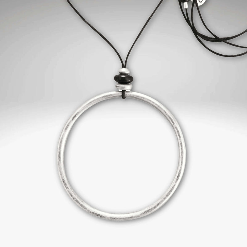 Hula Necklace featuring a 2" diameter raw brass circle hoop with asterling silver coating on a monofilament cord.