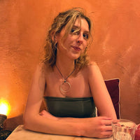 Hula Necklace worn by a woman with curly hair, showcasing its 2" diameter circle hoop design and elegant style.