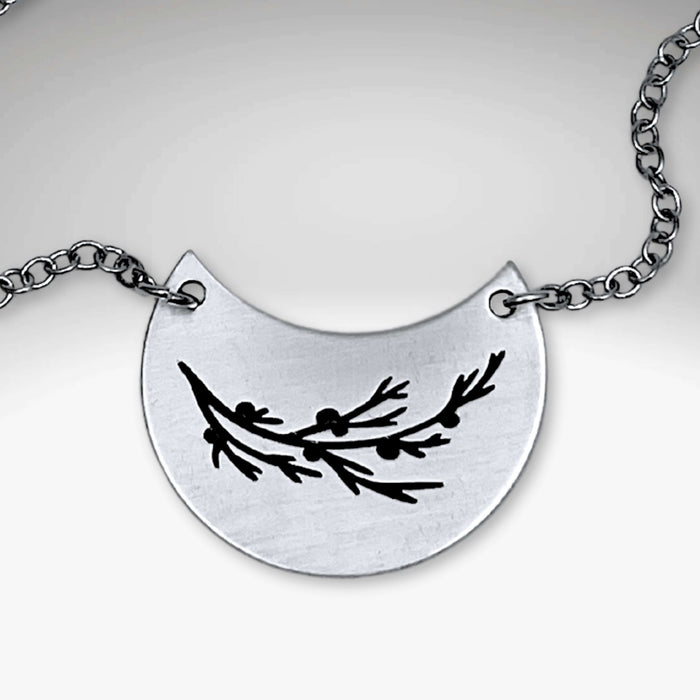 Juniper Necklace featuring a silver pendant with a Juniper sprig design on a rolo chain.