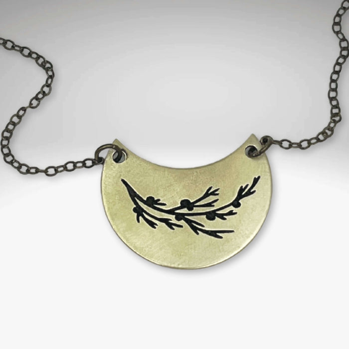Juniper Necklace featuring a pendant with a Juniper sprig design on an adjustable chain.