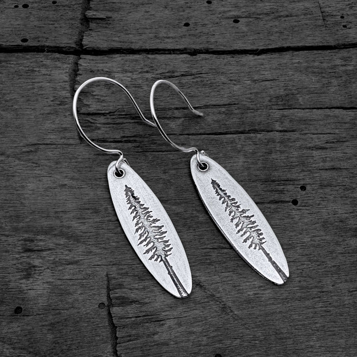 Larch Tree Earrings featuring etched larch tree design on raw brass, finished in matte silver.