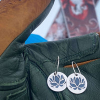 Lotus Flower Earrings displayed on a leather glove, showcasing their elegant lotus design and metallic finishes.