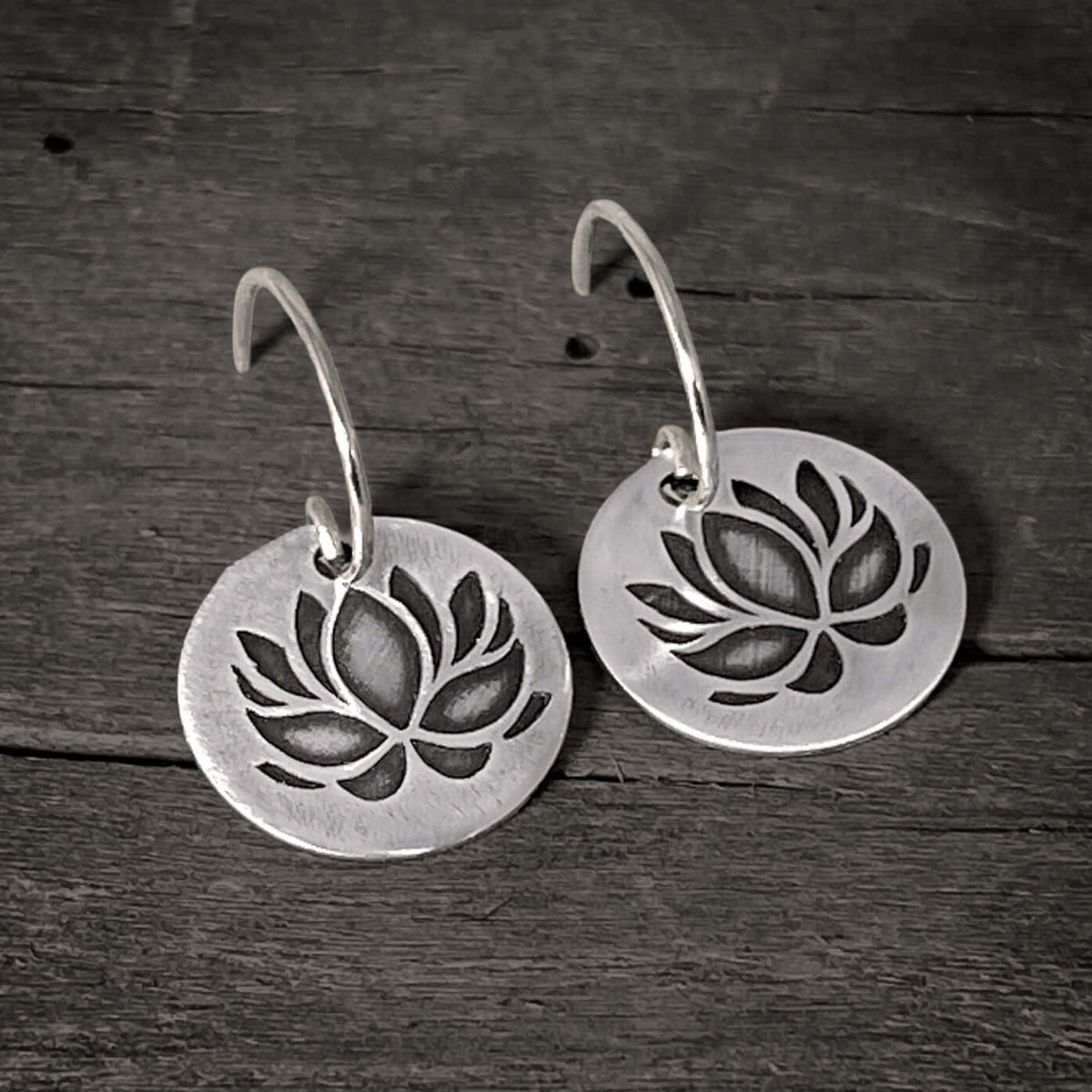 Lotus Flower Earrings showcasing a delicate silver design with a lotus pattern, symbolizing purity and resilience.