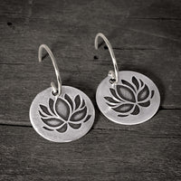 Lotus Flower Earrings showcasing a delicate silver design with a lotus pattern, symbolizing purity and resilience.