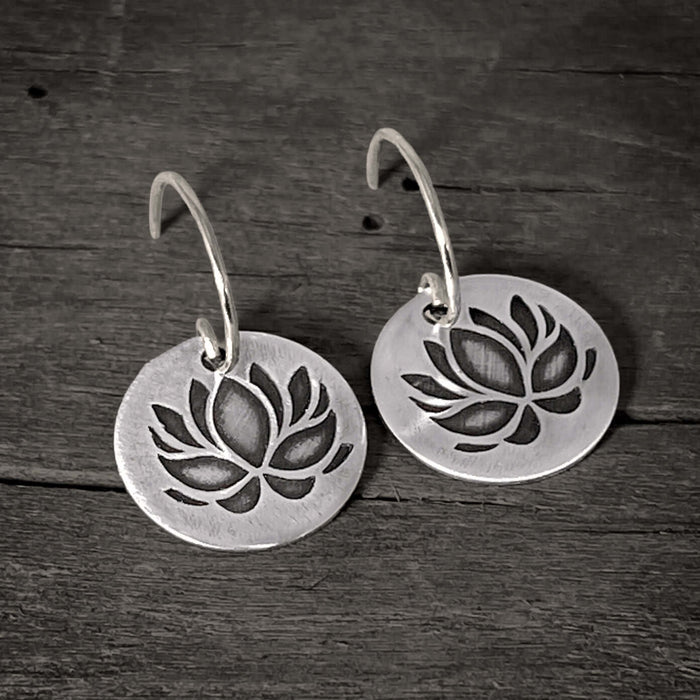 Lotus Flower Earrings showcasing a delicate silver design with a lotus pattern, symbolizing purity and resilience.