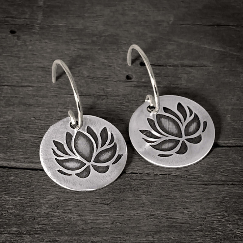 Lotus Flower Earrings showcasing a delicate silver design with a lotus pattern, symbolizing purity and resilience.