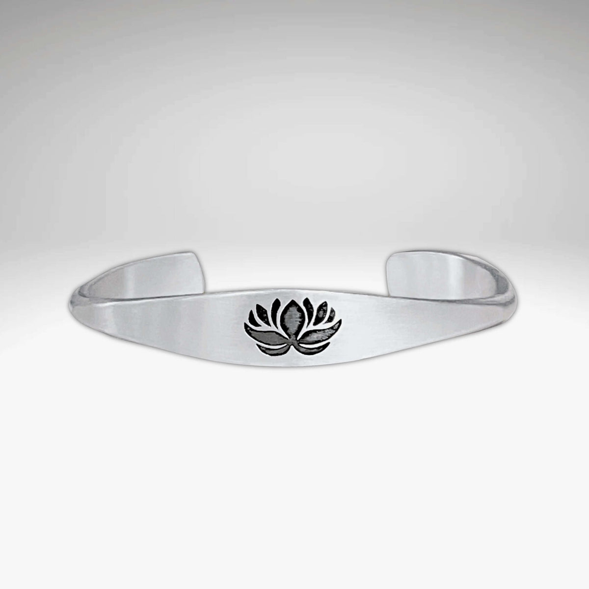 Lotus Signet Cuff Bracelet featuring a sleek silver design with a lotus motif.