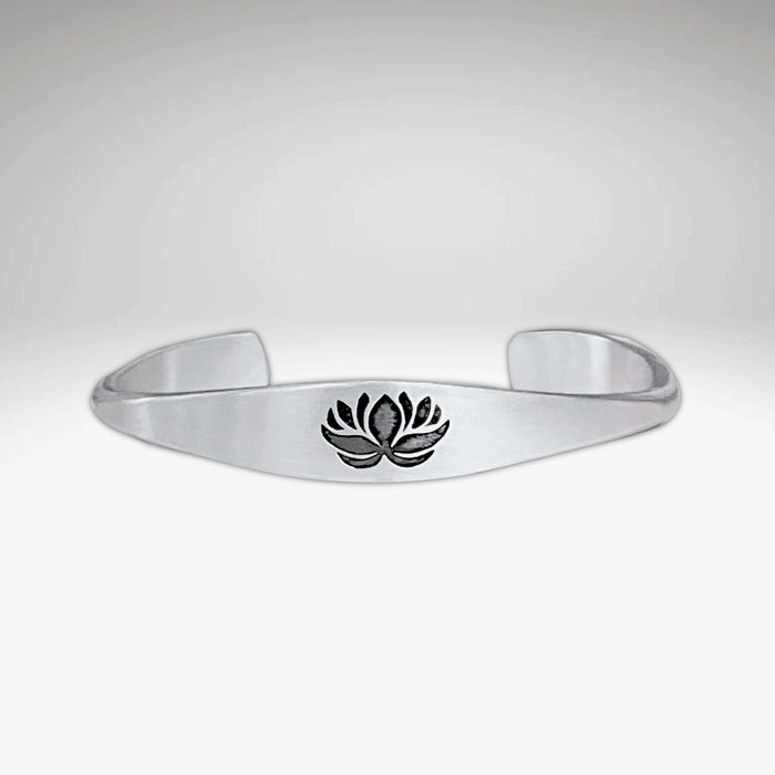 Lotus Signet Cuff Bracelet featuring a sleek silver design with a lotus motif.
