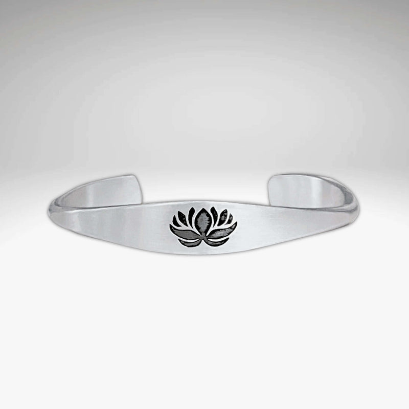 Lotus Signet Cuff Bracelet featuring a sleek silver design with a lotus motif.