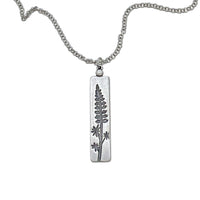 Lupine Necklace featuring a silver pendant with a wildflower design on an adjustable chain.