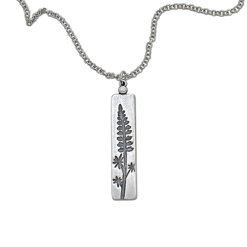 Lupine Necklace featuring a silver pendant with a wildflower design on an adjustable chain.