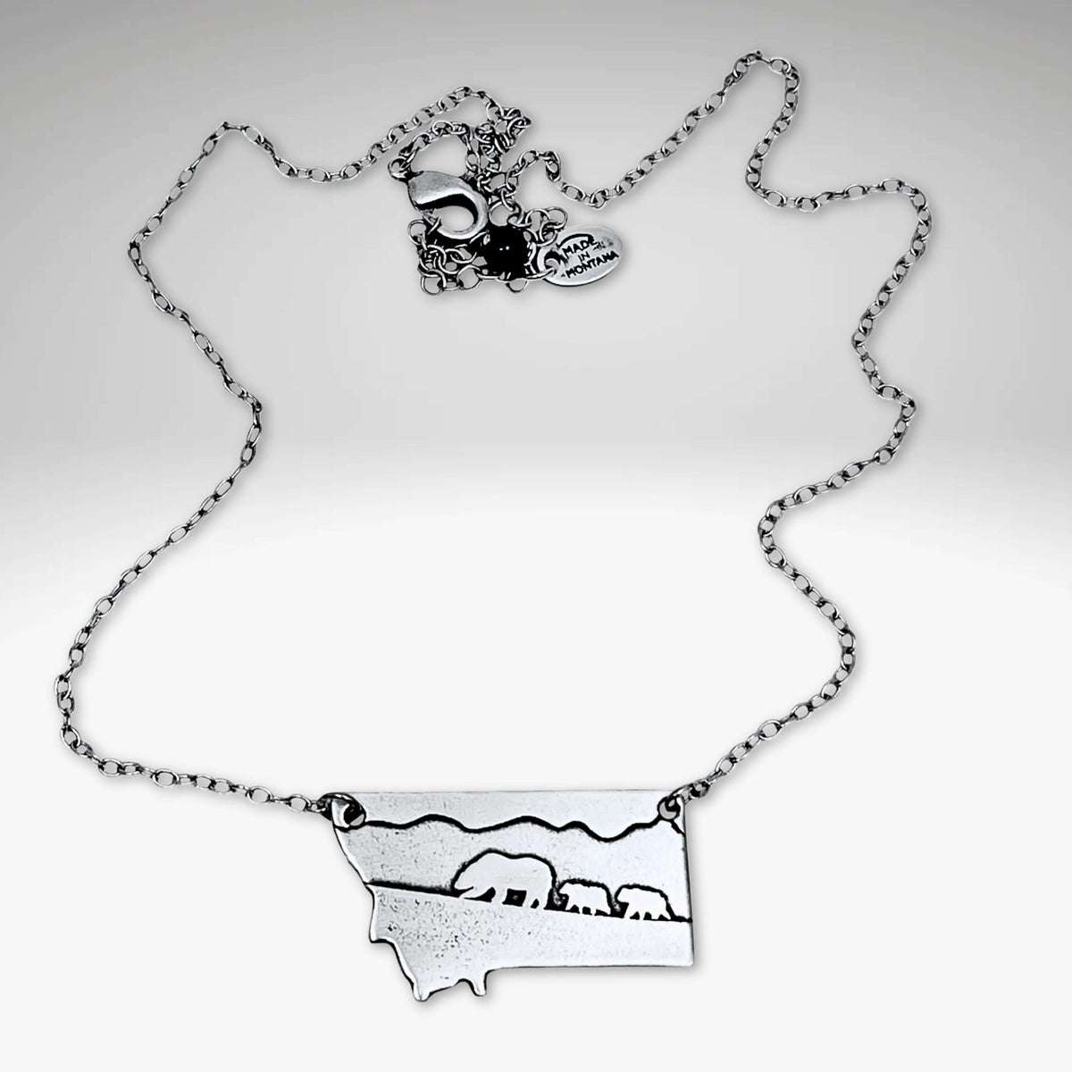 Mama and Cubs Necklace showcasing a mother grizzly bear and cubs, crafted in raw brass on an adjustable cable chain.