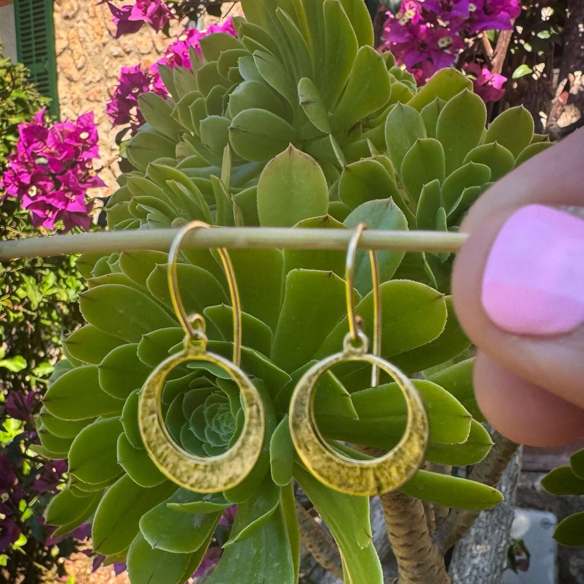 Mini Discs Earrings showcased in a garden, featuring hand hammered antique brass open discs for unique elegance.
