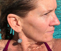 Model wearing Mini Sun Ray Hoop Earrings while enjoying the pool, showcasing their stylish design and sunray pattern.