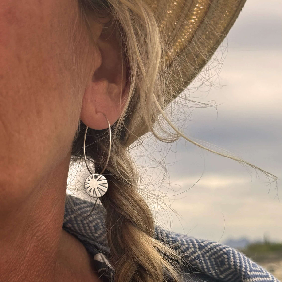 Woman wearing Mini Sun Ray Hoop Earrings, showcasing the sun-inspired design and stylish hoop style.