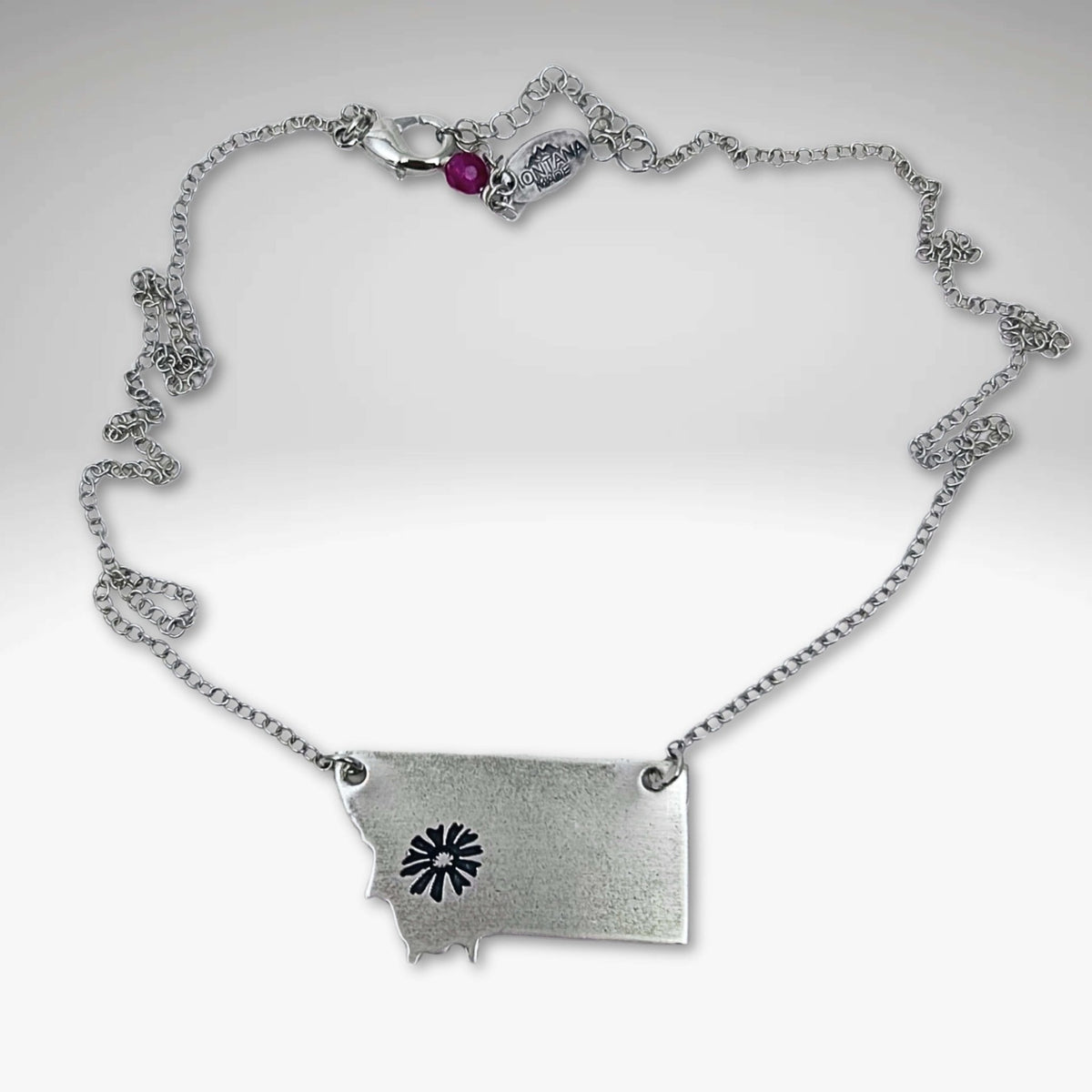 Montana Bitterroot Necklace shown in matte silver finish with state outline and sun design.