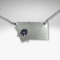 Montana Bitterroot Necklace featuring a Montana state silhouette and floral design in matte silver finish.