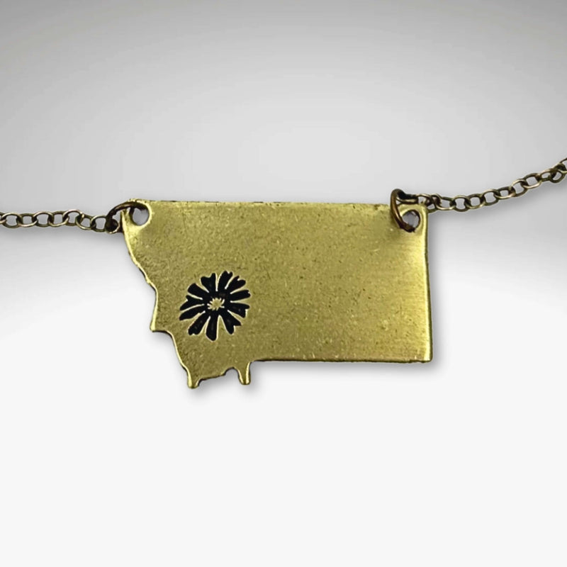 Montana Bitterroot Necklace showcasing a Montana state shape with a flower design in antique brass finish.