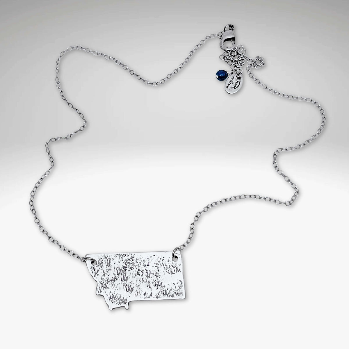 Montana Necklace featuring a textured Montana outline pendant on a light cable chain.