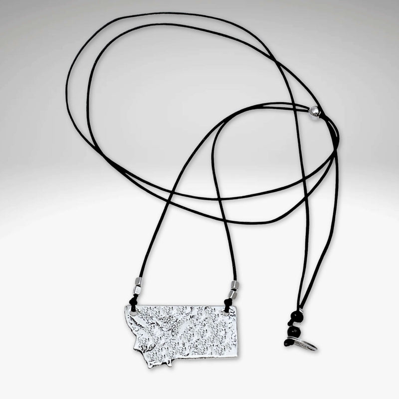 Montana Necklace featuring a hammered silver outline of Montana on a black adjustable cord.