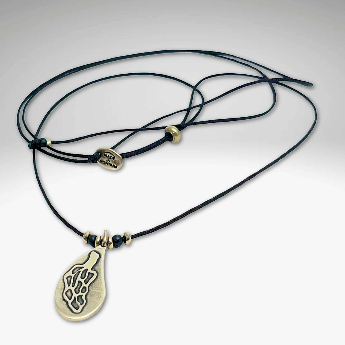 Morel Mushroom Necklace featuring a solid brass pendant on a leather cord with decorative beads.