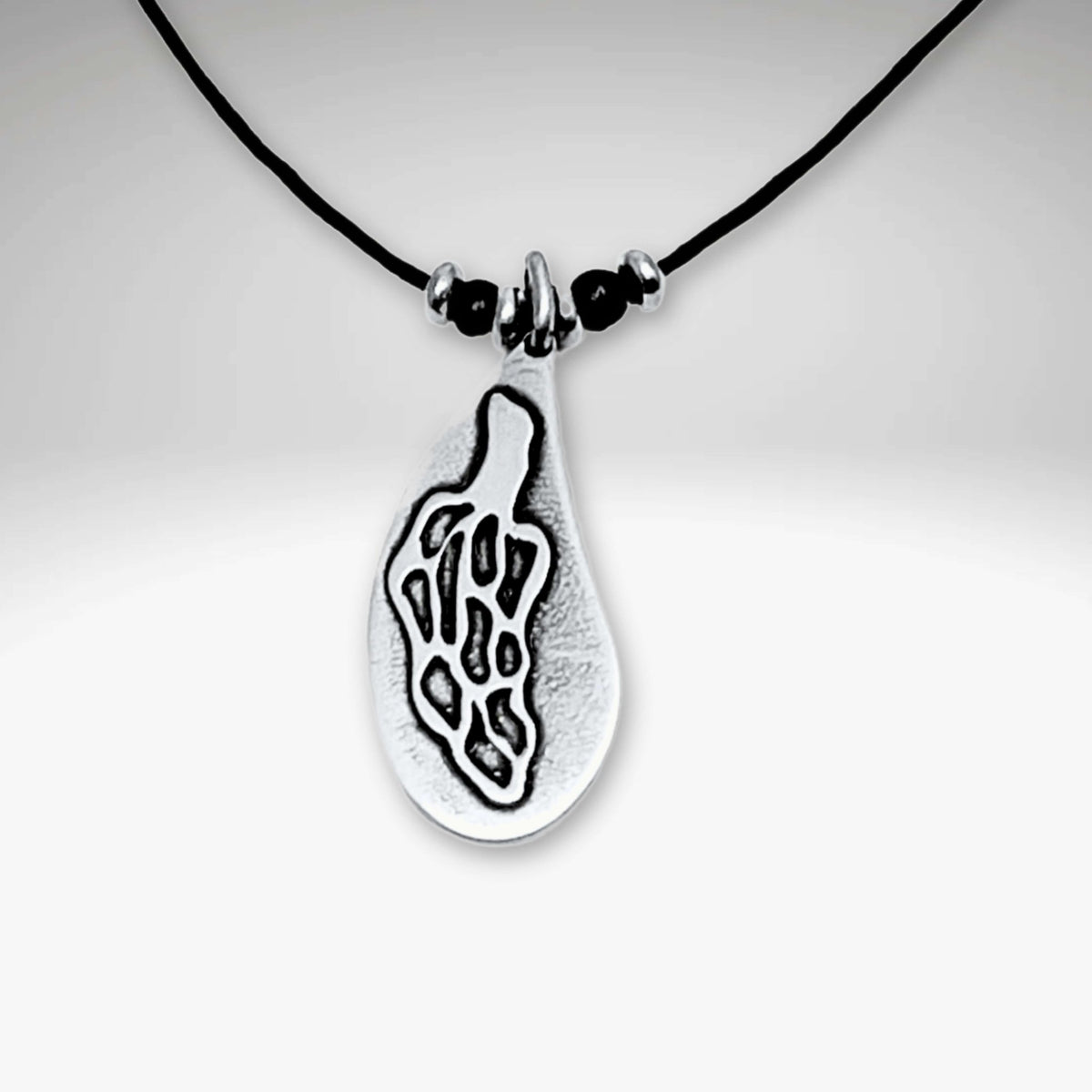 Morel Mushroom Necklace featuring an etched design on a pendant with black cord.