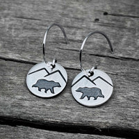 Mountain Bear Earrings in Matte Silver featuring etched bear and mountain design on circular discs.