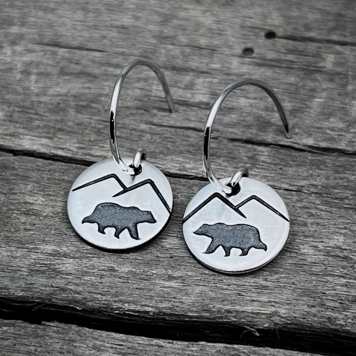 Mountain Bear Earrings in Matte Silver featuring etched bear and mountain design on circular discs.