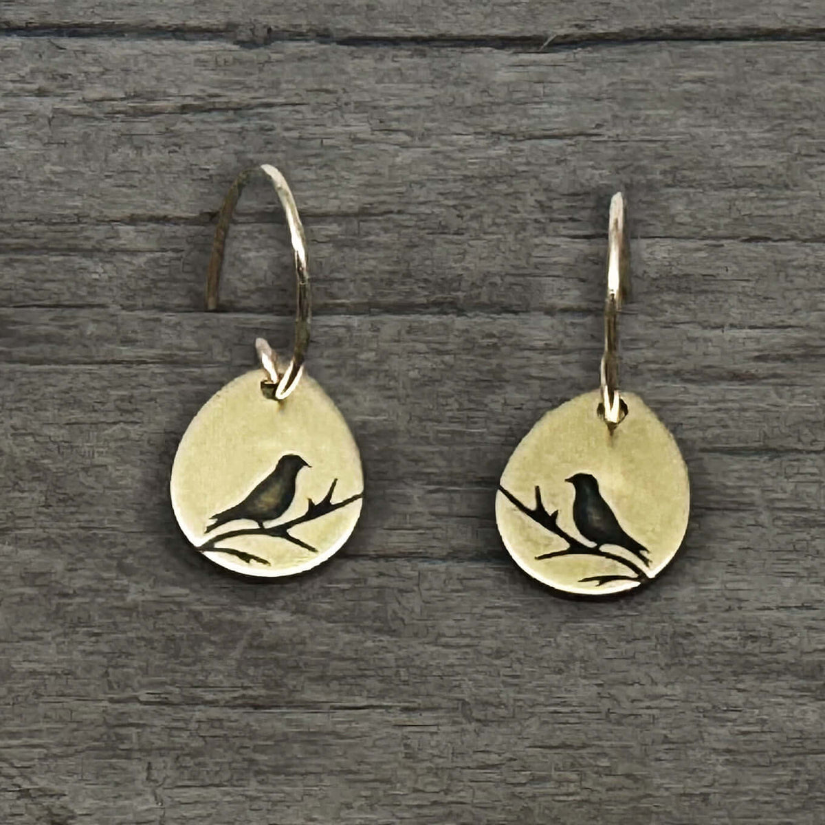 Mountain Bluebird Earrings featuring etched bluebirds on a teardrop shape in antique brass finish.